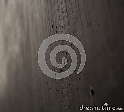 Gray monophonic background with textural holes in a concrete wall with cracks and drips. Stock Photo