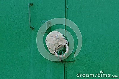 Gray padlock on the closed green metal garage door Stock Photo