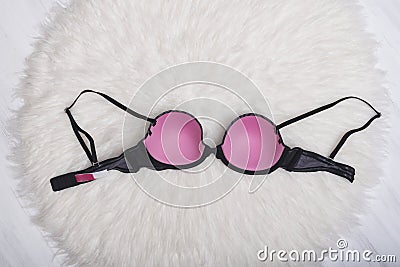 Gray-pink bra on white fur. Inner side. Fashion concept Stock Photo