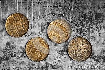 Gray shabby concrete wall with wicker handmade round tray. Eco style and concept Stock Photo