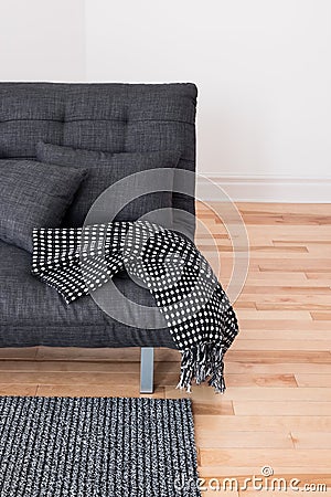 Gray sofa with cushions and throw Stock Photo