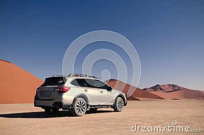 Gray Subaru in the sand of the Namib desert at a bright sky. Stock Photo