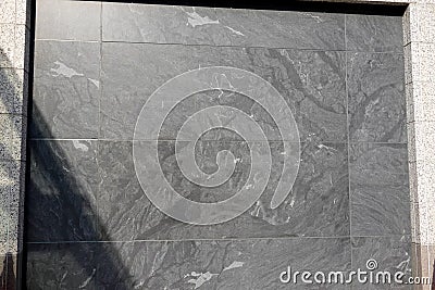 Gray textured flat Marble granite wall on the side of a building Stock Photo