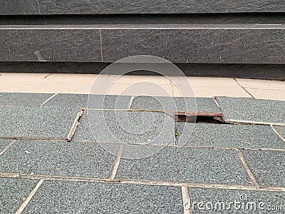 Gray tiles with cracks, floor collapses, cracked house problems Stock Photo