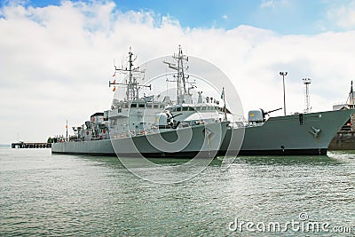 Gray war ships on the background of bright cloudy sky Stock Photo