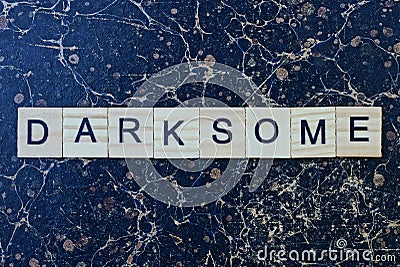 gray word darksome from wooden letters in black font Stock Photo