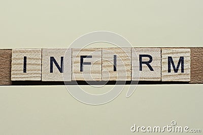 Gray word infirm of gray small wooden letters Stock Photo