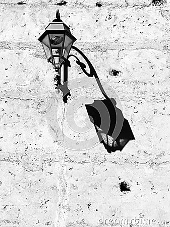 Grayscale of a lamp hanging from a wall Stock Photo