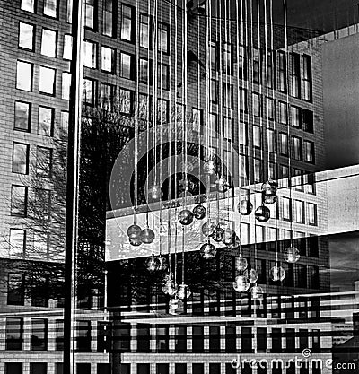 Grayscale shot of beautiful pendant luminaires hanging inside the glass building Editorial Stock Photo