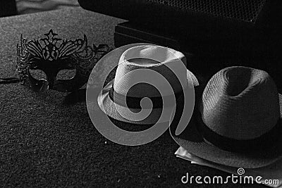 Grayscale shot of carnival mask and straw hats Stock Photo