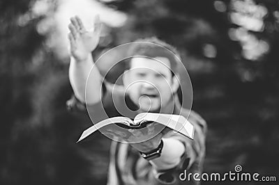 Grayscale shot of a male holding the Holy Bible and preaching it with a lot of enthusiasm Stock Photo