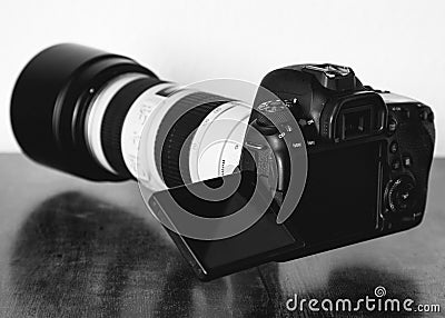 Grayscale shot of a professional DSLR camera on the table Editorial Stock Photo
