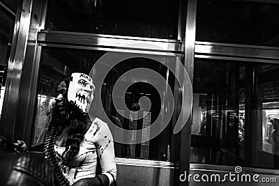 Grayscale shot of a woman with scary mask for Halloween in New York City Editorial Stock Photo