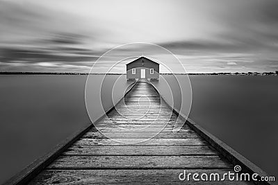 Grayscale shot of a wooden road leading to a lonely house - imaginary world concept Stock Photo