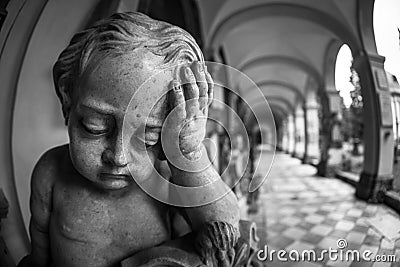 Grayscale of a stone sculpture of a sad boy in a hallway in a building in Salzburg, Austria Stock Photo