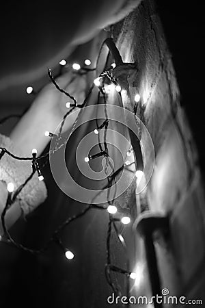 Grayscale vertical shot of lights hanging on a wall Stock Photo