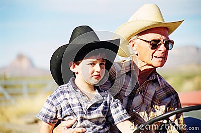 Great Grandfather and Grandson on Tractor Stock Photo