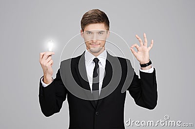 Great idea! Hansome young businessman holding a light bulb Stock Photo