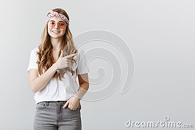 Great idea to stop by cafe. Indoor shot of beautiful creative stylish girl in headband and sunglasses pointing right Stock Photo