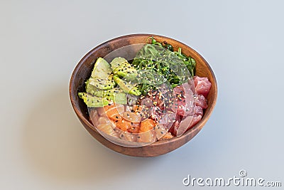 Great mixed poke bowl of marinated salmon and red tuna with ripe avocado, wakame seaweed salad, base white rice Stock Photo