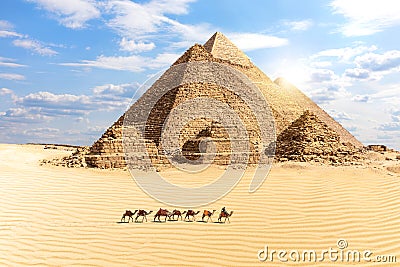 The Great Pyramids of Giza and a train of camels in the desert, Egypt Stock Photo