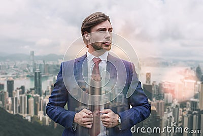Great style! Handsome young businessman adjusting his jacket and looking away while standing against of morning Stock Photo