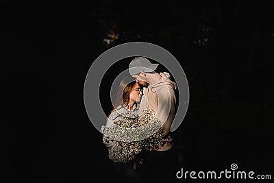 great view of couple in love with flower bouquet at dark. Romantic date. Love story Stock Photo