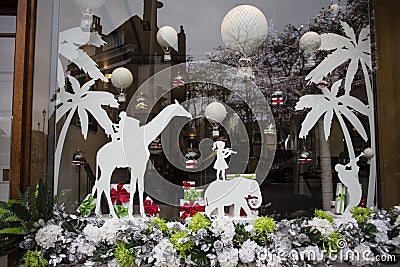 A great window design was observed for the holidays in London. balloons, elephants, Giraffe,little girl and palms, and Christmas Stock Photo