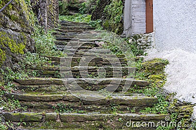 Greece, Tzia Kea island. Ioulis city narrow street with stairs and traditional stone walls Stock Photo