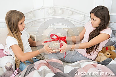 Greediness concept. Christmas atmosphere. Making surprise. Wrapped present. It is for me. Small girls in bed on Stock Photo