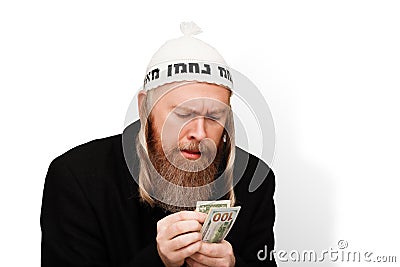 Greedy bearded jewish man counting his money. Thrifty jew with sidelocks in white yarmulke isolated on white background Stock Photo