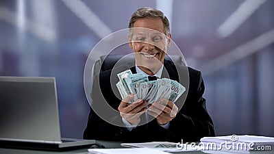 Greedy businessman holding bunch of dollars, rejoicing easy income, high salary Stock Photo