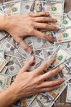 Greedy hands clutching 100 dollar banknotes. Greed, business Stock Photo