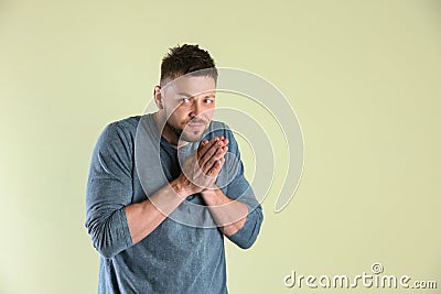 Greedy man rubbing hands on light background, space for text Stock Photo