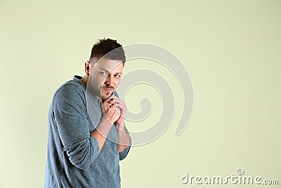 Greedy man rubbing hands on light background, space for text Stock Photo