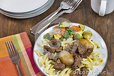 Greek beef stifado with egg noodles and roasted vegetables Stock Photo