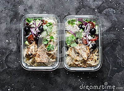 Greek chicken grain lunch box. Lemon herbs chicken, couscous, vegetables, olives, feta cheese lunch box on dark background, top Stock Photo