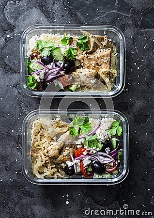 Greek chicken grain lunch box. Lemon herbs chicken, couscous, vegetables, olives, feta cheese lunch box on dark background, top Stock Photo