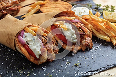 Greek gyros wrapped in pita breads on a black dish Stock Photo