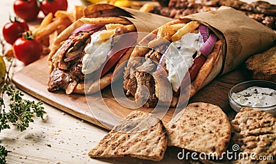 Greek gyros wrapped in pita breads on a wooden table Stock Photo