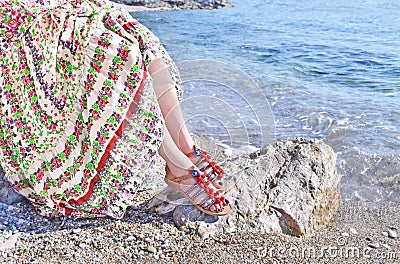 Greek model advertises bohemian sandals and clothes at the beach Stock Photo