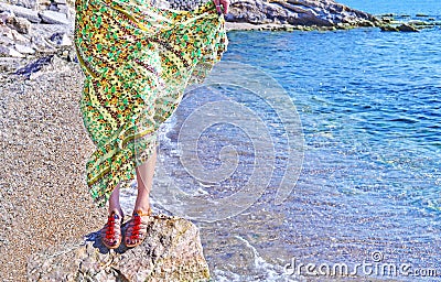 Greek model advertises bohemian sandals and clothes at the beach Stock Photo