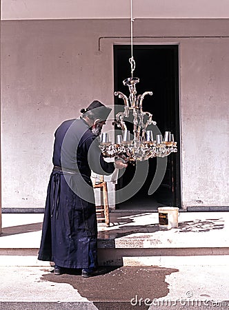 Greek Monk cleaning a light, Cyprus. Editorial Stock Photo