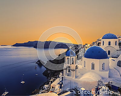 The Greek Orthodox Church on the background waters of the Aegean sea in Oia at sunset. The Island Of Santorin Stock Photo