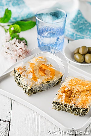 Greek pie spanakopita on the white plate with accessorizes vertical Stock Photo