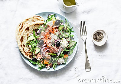 Greek salad with baked salmon on a light background, top view. Healthy mediterranean diet food Stock Photo