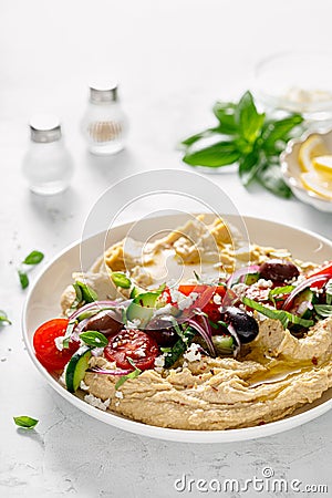 Greek style vegan mediterranean hummus with fresh vegetables, olives, olive oil and feta cheese Stock Photo