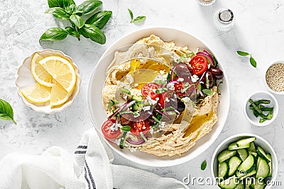 Greek style vegan mediterranean hummus with fresh vegetables, olives, olive oil and feta cheese. Top view Stock Photo