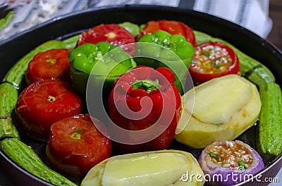 Greek traditional food Gemista in round oven tray ready to be cooked. Stuffed peppers, tomatoes, zucchini, potatoes and onion wit Stock Photo