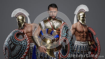 Greek warlord with two comrades against grey background Stock Photo